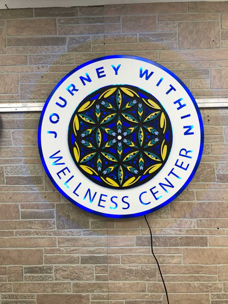 Journey Within Wellness Center round sign with a blue and gold mandala inside a lettered ring.