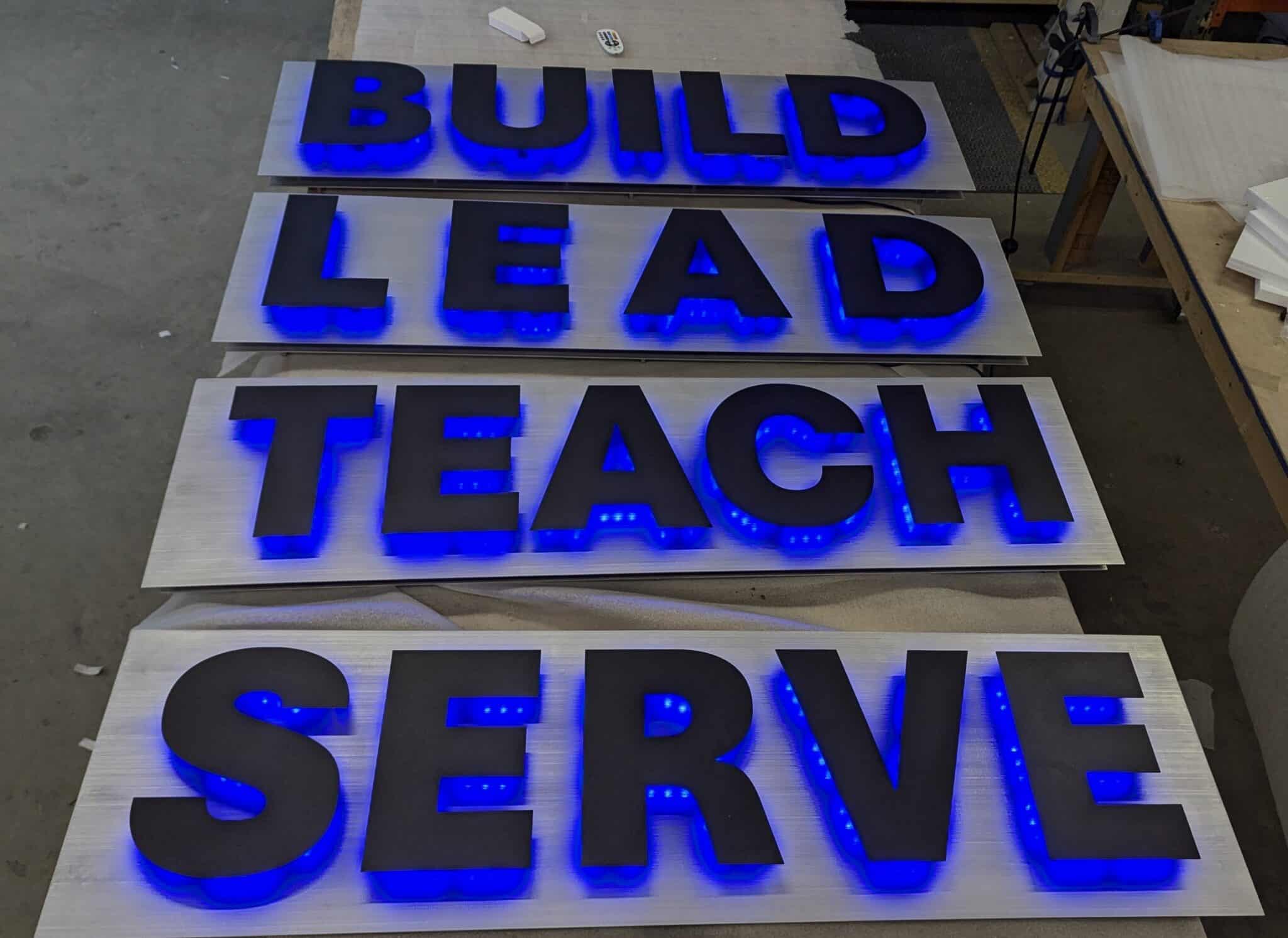 Backlit metal logo sign for the 57th Weapons Squadron glowing on an interior wall