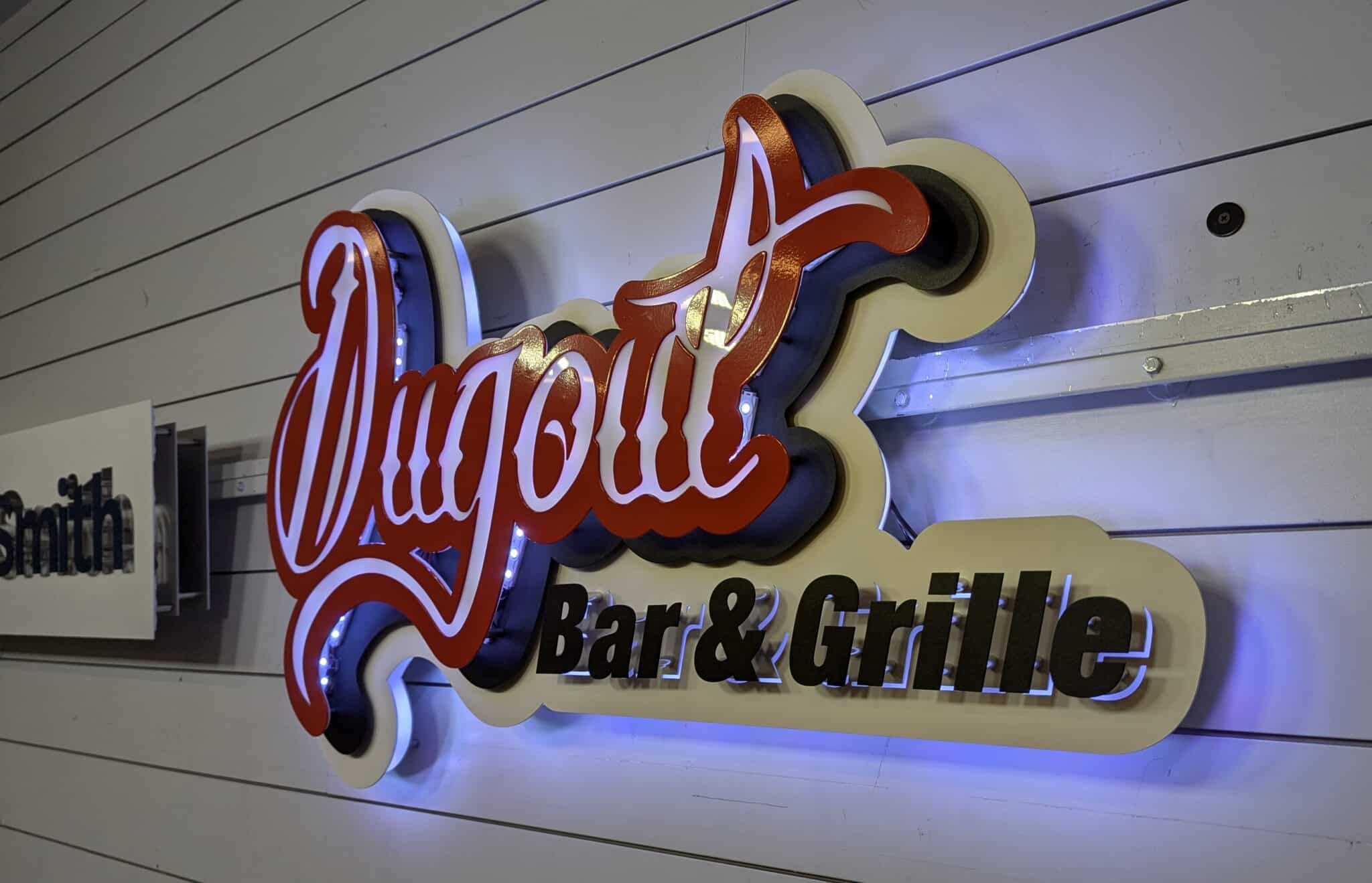 Custom metal restaurant sign installed at Dugout Bar and Grille exterior storefront