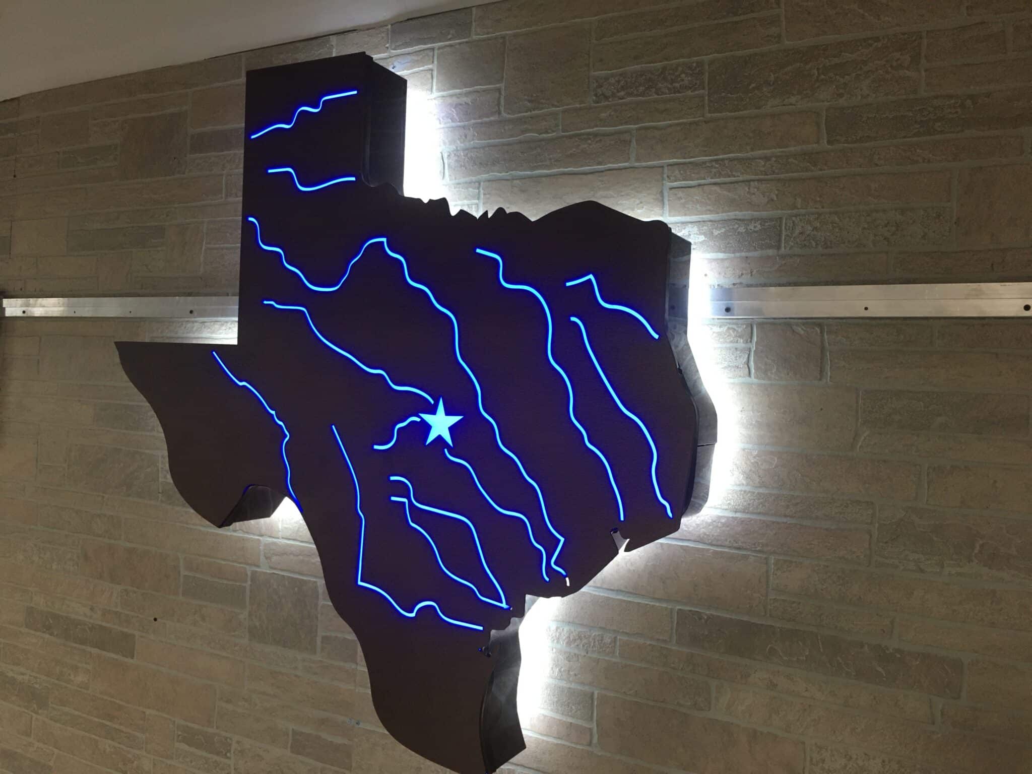 Large illuminated metal logo sign with backlit and halo-lit elements showcasing fabrication detail