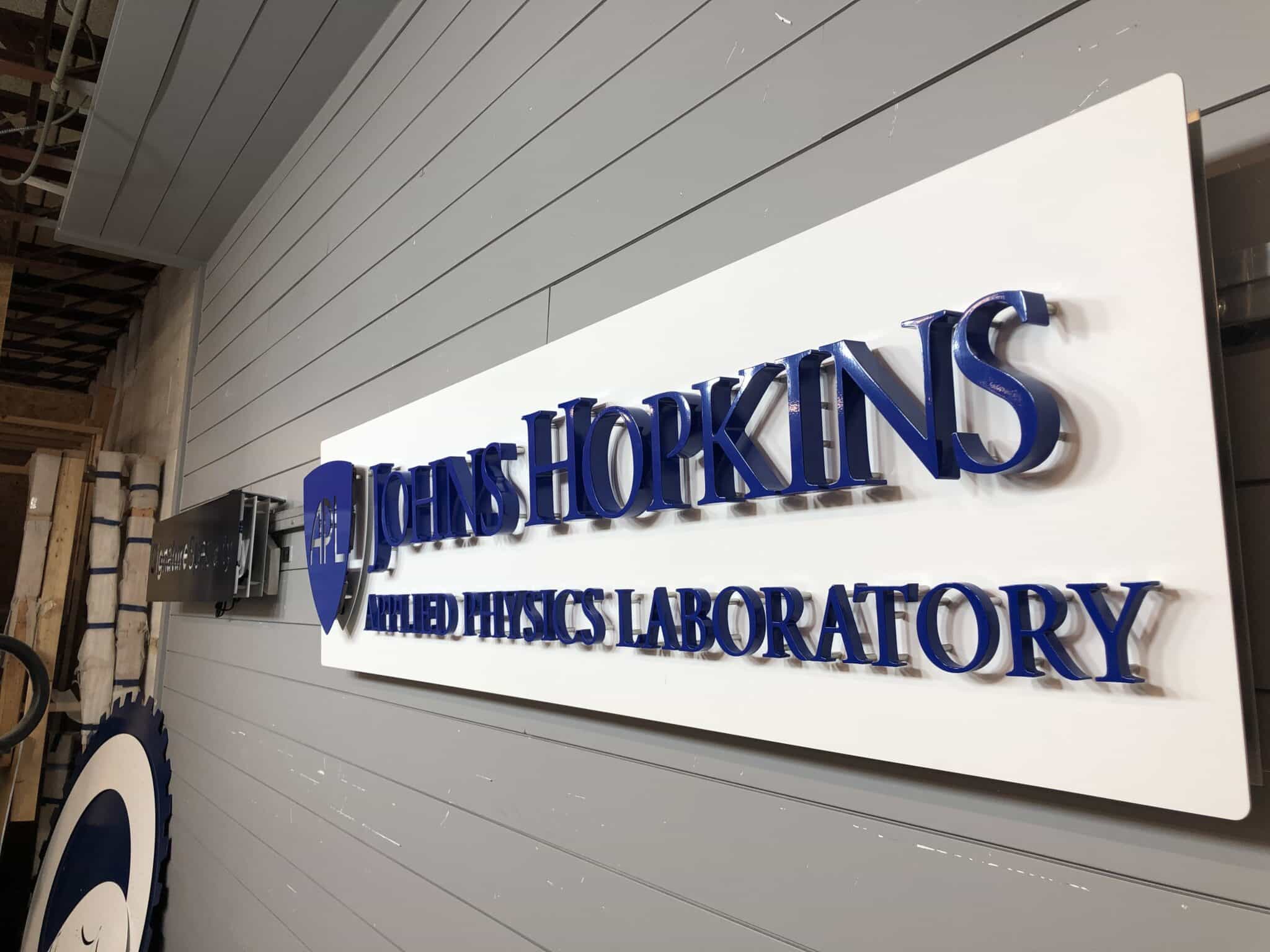 Halo-lit brushed metal logo sign in an interior lobby, typical of custom medical office signs