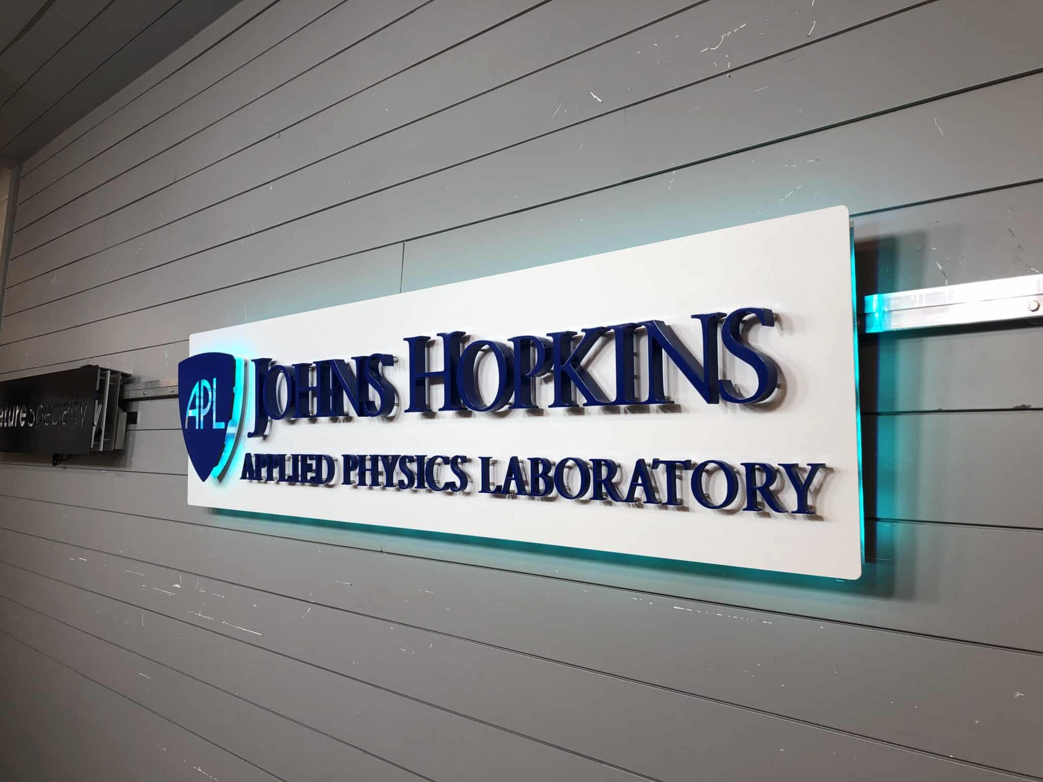 Halo-lit custom metal logo sign for Johns Hopkins APL, a precision fabrication example from a custom metal sign company