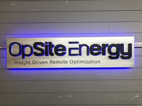Custom backlit metal logo sign for OpSite Energy company showing precision metal fabrication and LED lighting integration