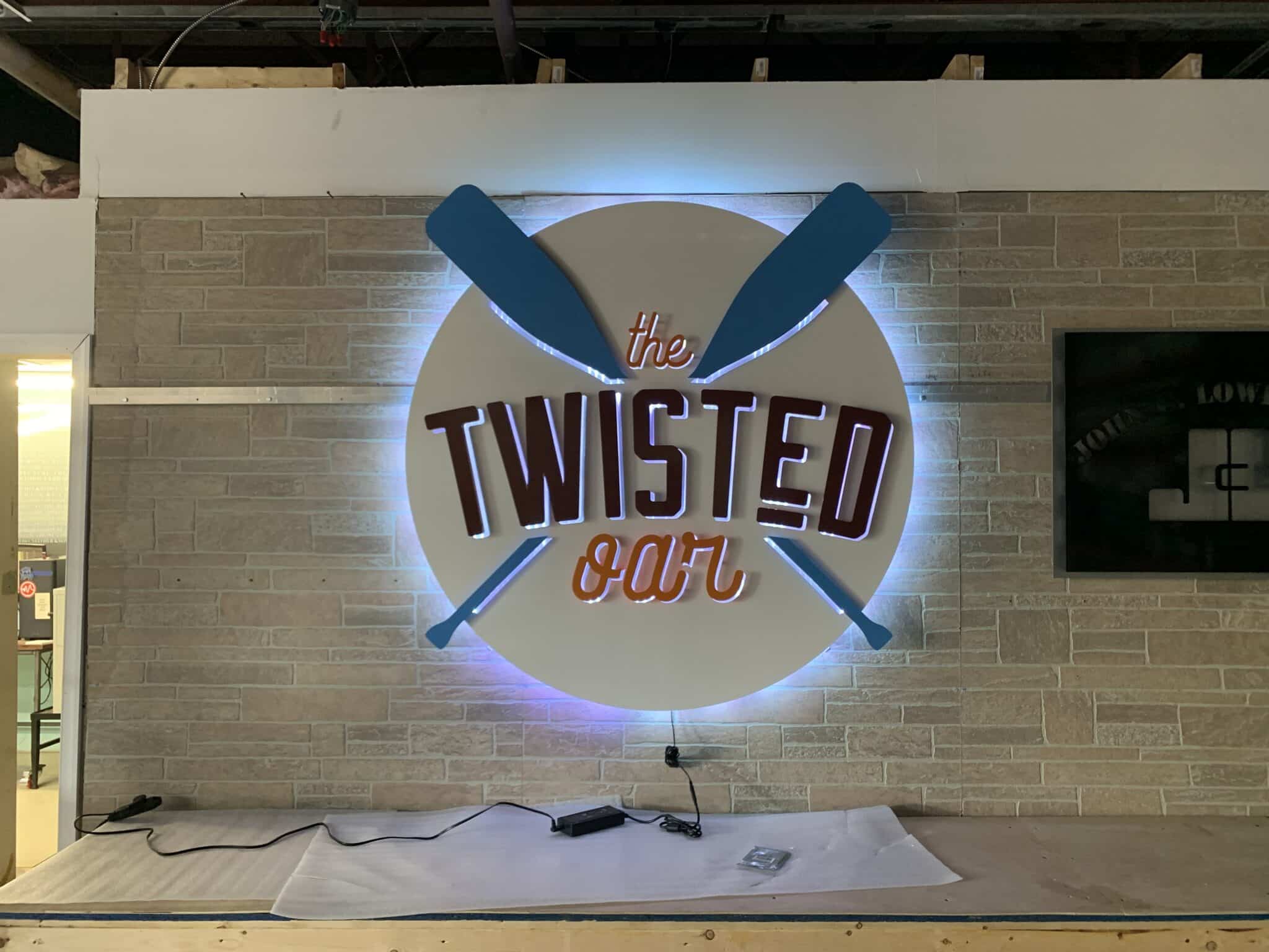 The Twisted Oar backlit metal business sign with warm LED illumination