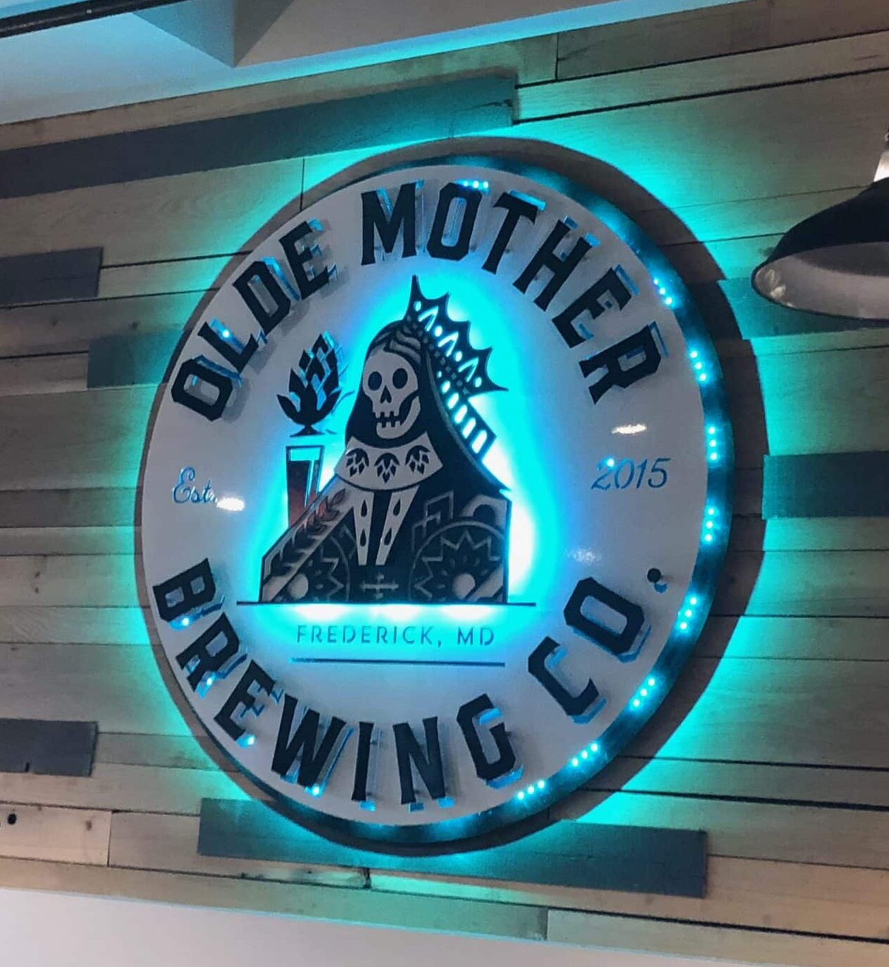 Olde Mother Brewing Co. round sign for Frederick, Maryland, halo-lit LED and glowing cyan.