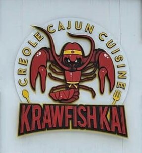 Krawfish Kai Creole Cajun Cuisine round sign with a crawfish mascot above the name.
