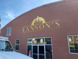 Cannon's building sign in gold lettering across the brick facade, photographed from the parking lot.