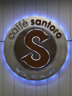 custom illuminated sign for the caffe santoro in distressed aluminum metal with powder coating for interior use