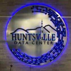Huntsville Data Center round sign with a rocket and ridgeline, a blue LED arc sweeping around the rim.