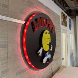 Adolph's sign seen from the side, the red LEDs visible around the rim of the black disc.