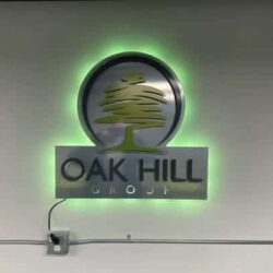 Oak Hill Group sign with a stylized oak above the name, halo-lit LED and glowing green.