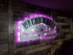 Wagon Wheel sign with the halo switched to magenta, the wagon wheel spokes in silhouette.