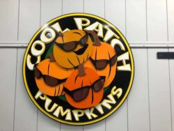 Cool Patch Pumpkins round sign with three pumpkins in sunglasses inside a yellow ring.