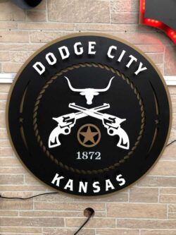 Dodge City, Kansas round sign with a longhorn skull over crossed revolvers inside a rope border.