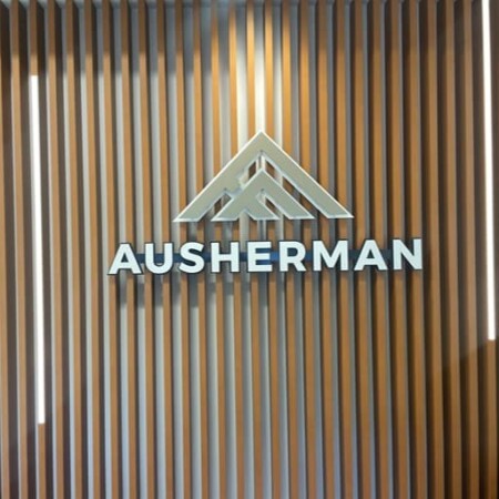 Ausherman dimensional letters with a peaked roof mark above, mounted on a slatted timber wall.