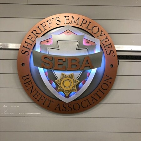 Sheriff's Employees' Benefit Association seal in copper with a SEBA banner across a star badge.
