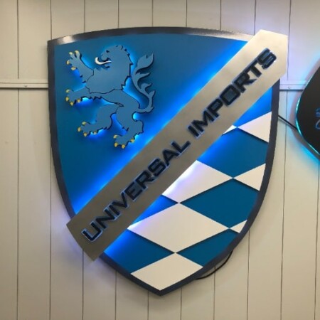 Universal Imports of Rochester shield sign with a heraldic lion above a blue and white diamond field.