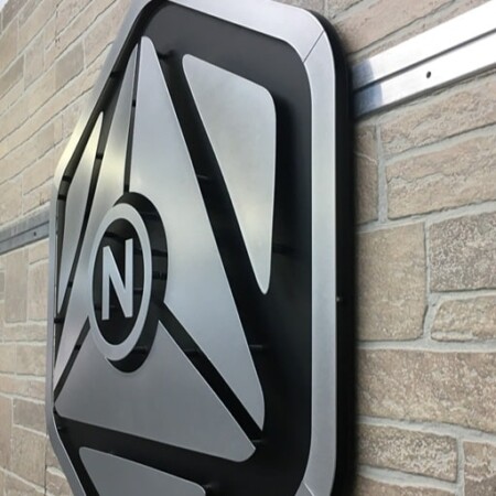 NeuroScouting sign seen from the side, the faceted layers stepping back from the brushed outer edge.