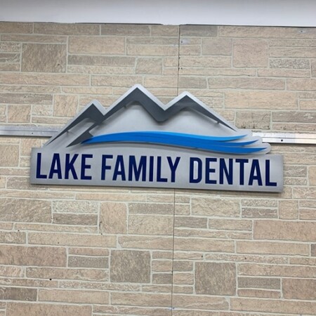Layered brushed aluminum logo sign for Lake Family Dental in silver/gray brushed metal and dark blue.