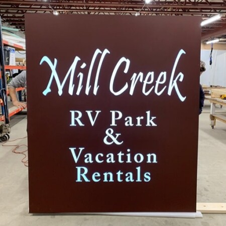 Mill Creek RV Park & Vacation Rentals face-lit led panel standing in the shop, white script on a deep brown face.