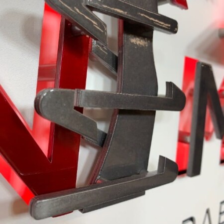 Close view of the Iron Mountain letters, brushed steel returns over red acrylic edges.
