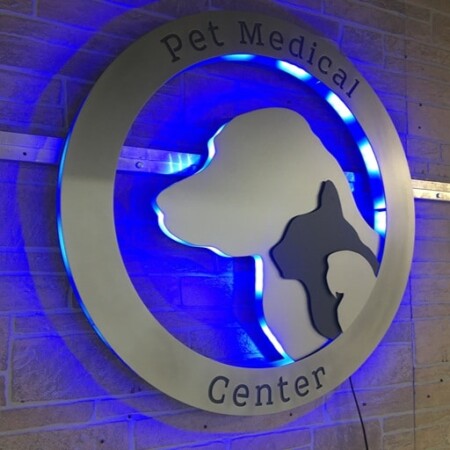 Pet Medical Center of Pasco sign from the other side, the cat and dog profiles picked out against the glow.