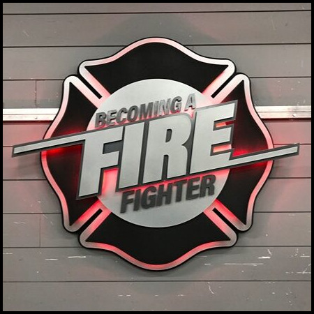 Becoming a Fire Fighter Maltese cross sign in black and silver, halo-lit LED and glowing red.