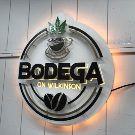 Bodega on Wilkinson halo-lit LED ring sign with a coffee cup and beans, glowing warm amber.
