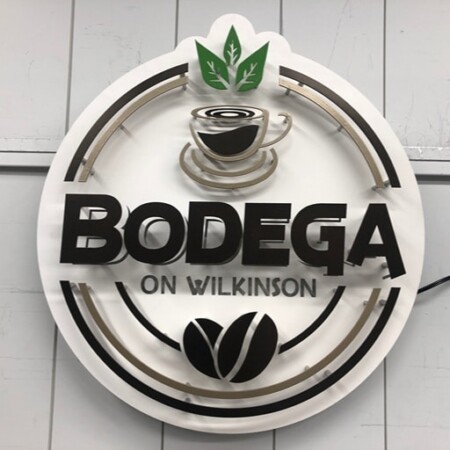 Bodega on Wilkinson halo-lit LED ring sign with a coffee cup and beans, glowing warm amber.