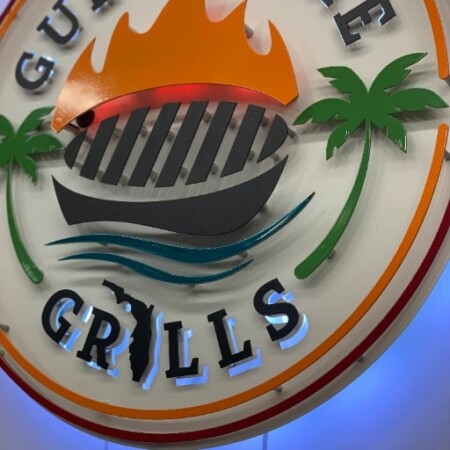 Gulf Shore Grills round sign with a flaming grill between palm trees, halo-lit LED and glowing blue.