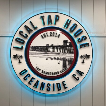 Local Tap House sign straight on with a cyan halo, Tap Something Local set beneath the pier photograph.