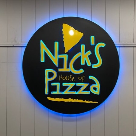 Nick's House of Pizza round sign with a yellow pizza slice above hand-drawn lettering, glowing blue.