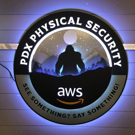 PDX Physical Security sign angled on the wall, See Something? Say Something! beneath the moonlit ridgeline.