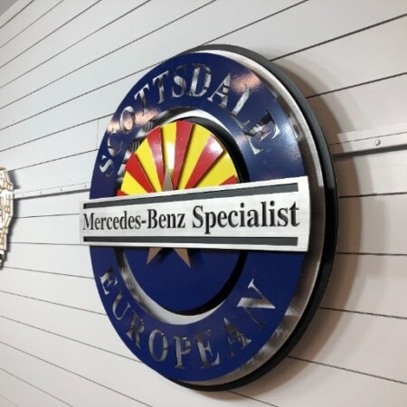 Scottsdale European sign angled off the wall, the navy ring and name bar standing well clear of the siding.