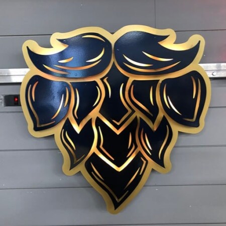 The Grand Barber sign shaped as a layered beard and moustache in black and gold.