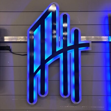 Elevate Wealth Management monogram sign in black, halo-lit LED and glowing blue.