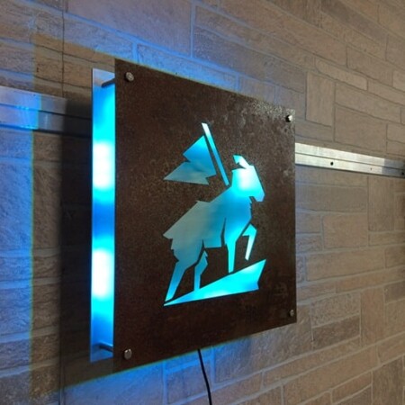 Crook and Marker cut-out plate sign, the figure knocked clean out of the steel and backlit cyan.