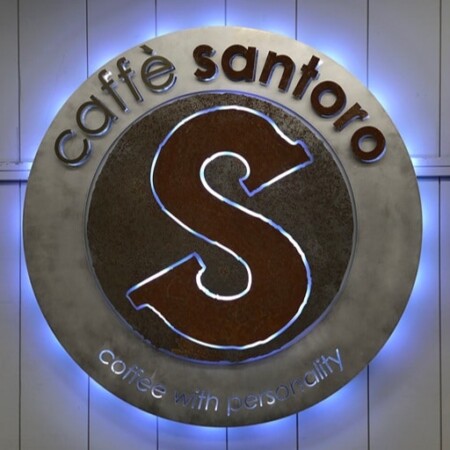 Caffè Santoro halo-lit LED round sign with a rusted steel S on a brushed disc, glowing blue.