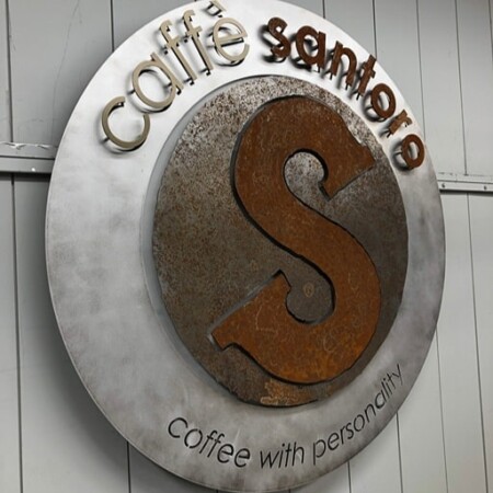 Caffè Santoro halo-lit LED round sign with a rusted steel S on a brushed disc.