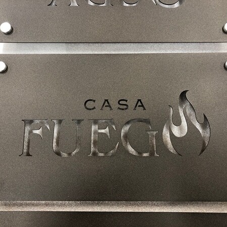 Casa Campos laser-cut plaque sign in dark steel with the name knocked out of the plate, floated on four corner standoffs.
