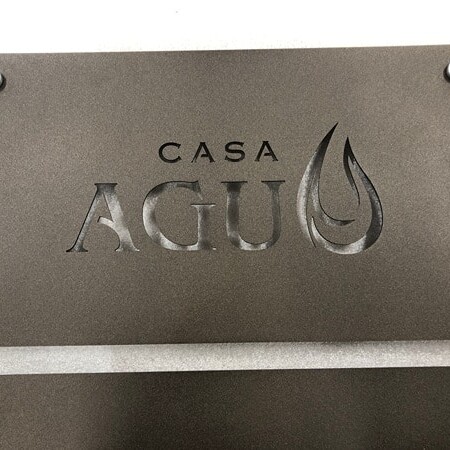 Casa Campos laser-cut plaque sign in dark steel with the name knocked out of the plate, floated on four corner standoffs.