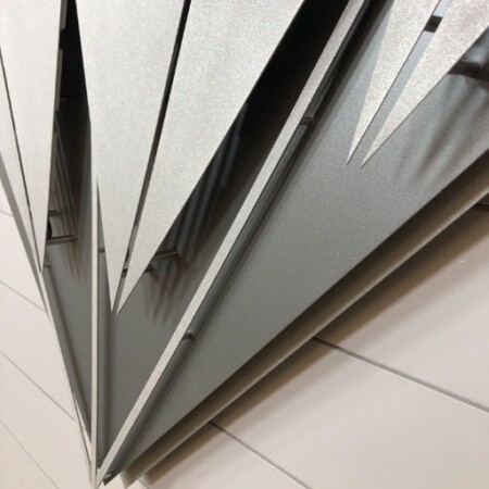 Close view of the Diamond Equity Investments diamond, the layered facets raking across the wall.