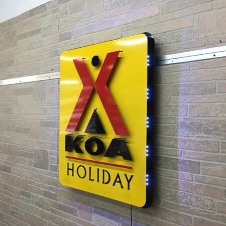 Layered powder-coated aluminum halo-lit sign for KOA campground in gloss yellow and red.