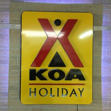 Layered powder-coated aluminum halo-lit sign for KOA campground in gloss yellow and red black.