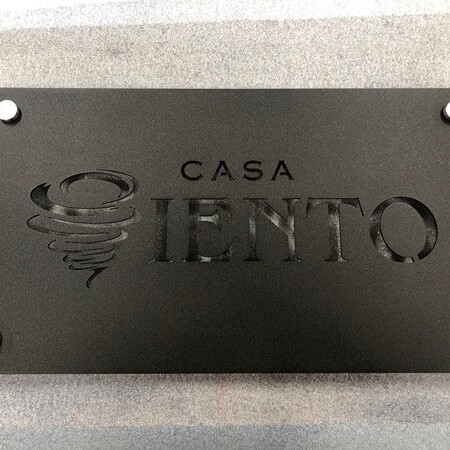 Powder-coated aluminum logo plaque sign for Casa Campos in matte/texture black and silver hardware.