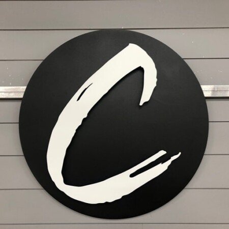 Covenant Church round sign in matte black with a white brushstroke C.