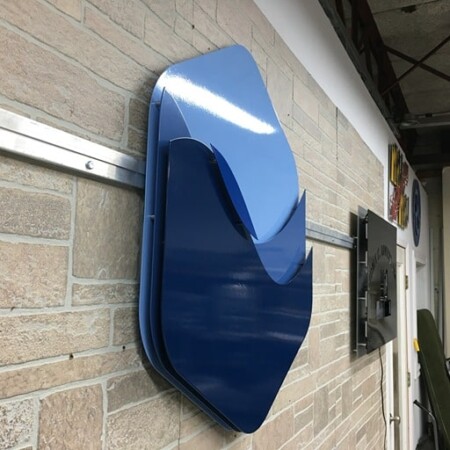 The Encore Dredging Partners mark from the side, its curved gloss face standing well off the wall.