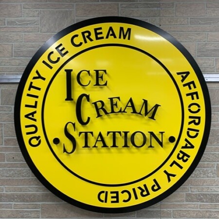 Ice Cream Station round sign in yellow and black, Quality Ice Cream Affordably Priced set around the rim.