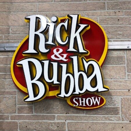 The Rick & Bubba Show sign straight on, the layered script standing well clear of the red backer.