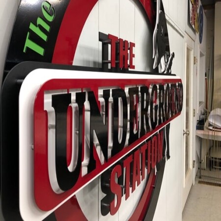 The Underground Station sign raking away down the shop wall, showing the depth of the lettering.